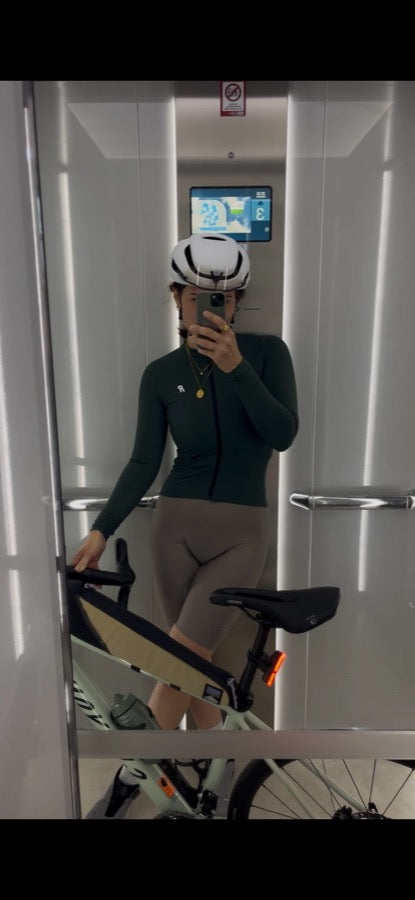 Cyclist taking a mirror selfie in an elevator with her road bike