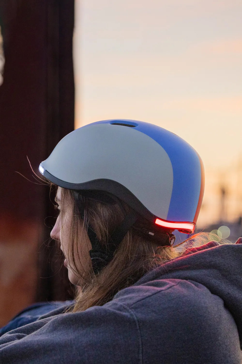 Girl at sunset wearing Lumos Nyxel Kids in Gradient Sweep with the rear light on